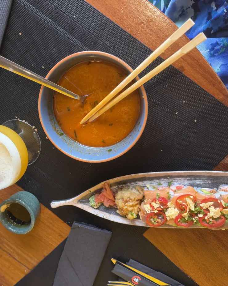 Photo réelle de repas : Soupe, makis saumon & cocktail au restaurant